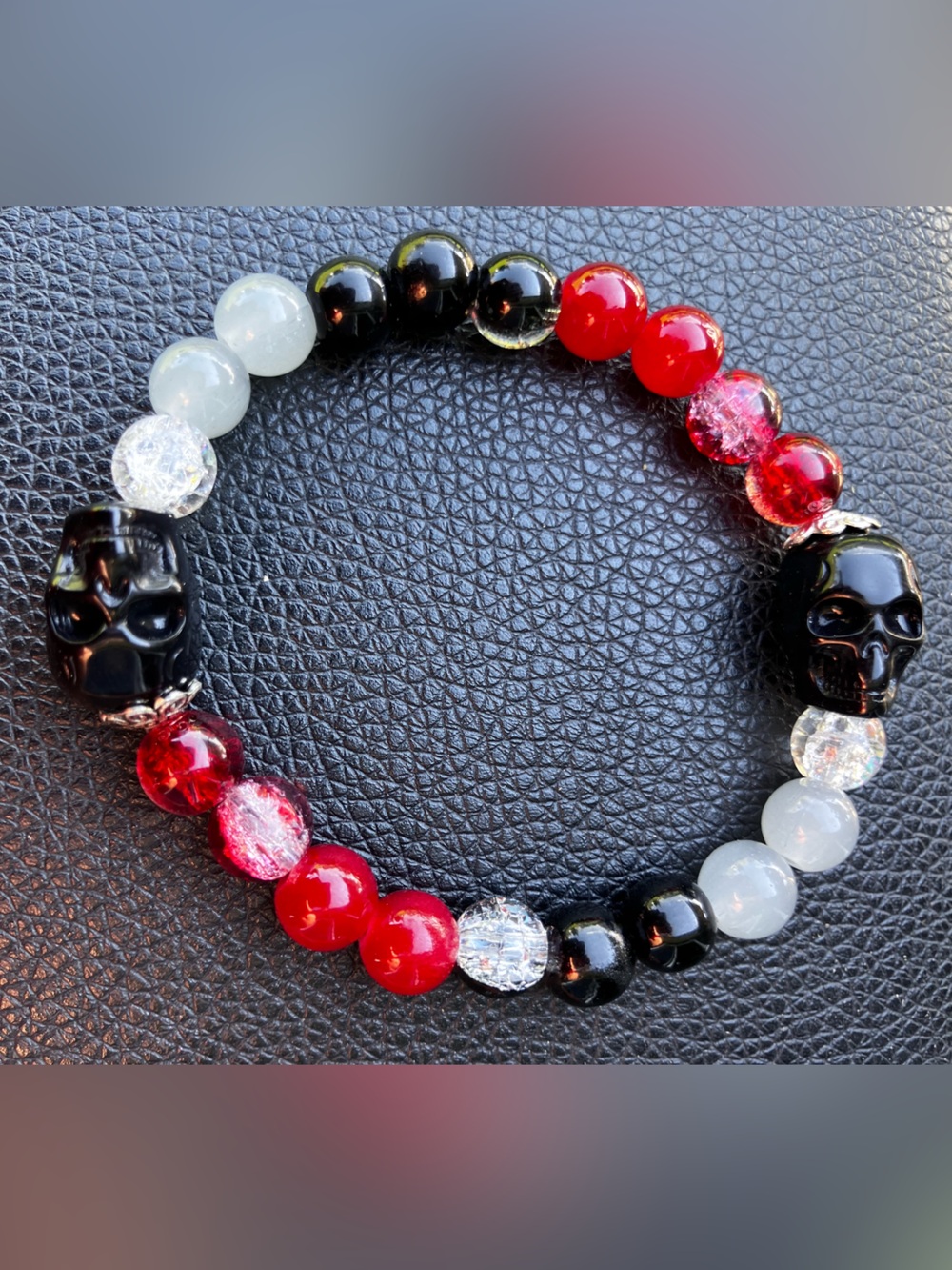 Ruby’s black skull bracelet/red